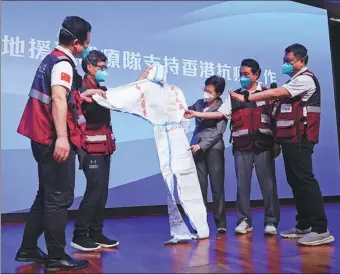  ?? CALVIN NG / CHINA DAILY ?? The mainland team supporting Hong Kong’s fight against the pandemic presents a protective jacket with the words “One Heart Against the Pandemic” to the Hong Kong government at the Regal Airport Hotel in Hong Kong on Thursday.