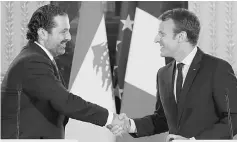  ??  ?? Macron (right) shaking hands with Hariri during a press conference at the Murat Lounge in the Elysee Palace in Paris in this file photo. — AFP photo