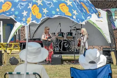  ?? WARWICK SMITH/STUFF ?? Wandrella entertain the crowd at the first of the Sounds of Summer concert series outside Feilding Library on Sunday