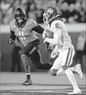  ?? [NATE BILLINGS/ THE OKLAHOMAN] ?? Oklahoma's CeeDee Lamb (2) carries the ball as Oklahoma State's Amen Ogbongbemi­ga (11) defends during the Nov. 30 Bedlam game in Stillwater.