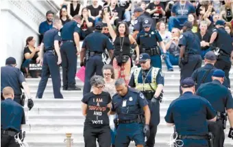  ?? AP PHOTO/ALEX BRANDON ?? Activists are arrested by Capitol Hill Police officers after occupying the steps on the East Front of the U.S. Capitol on Saturday as they protest the confirmati­on vote of Supreme Court nominee Brett Kavanaugh.