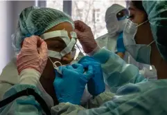  ?? (FP via Getty) ?? Medical workers get ready for a shift treating coronaviru­s patients at the Spasokukot­sky clinical hospital in Moscow