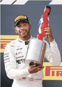  ?? AP ?? Lewis Hamilton celebra la conquista de su victoria ayer encima de un automovil.