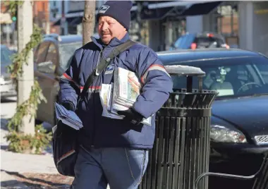  ??  ?? "You got to dress warm and just keep on moving," says Gary Szalewski, a U.S. Postal Service letter carrier, as he delivers mail in the cold along N. Downer Ave. near E. Belleview Place in Shorewood.