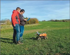  ?? AP/KELVIN CHAN ?? Joe Allnutt (left) and Thomas Burrell with British startup Small Robot Co. operate a farming robot named Tom during a trial Friday in East Meon, England.