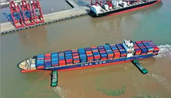  ?? Virginia YAO FENG / FOR CHINA DAILY
Left: Customers try out products at a Decathlon store in Jiaxing, Zhejiang province. QIU DAOQIN / FOR CHINA DAILY ?? Above: On Feb 21, 2021, the CMA CGM container ship docks at the Ningbo-Zhoushan Port.