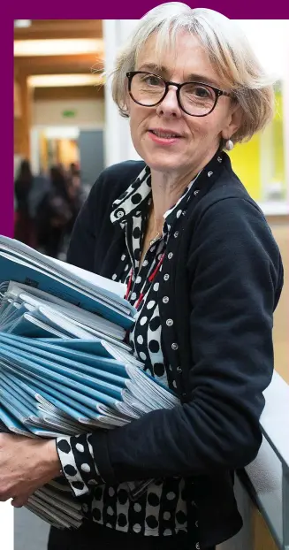  ??  ?? On your marks: Teacher Lucy with a pile of pupils’ exercise books to read