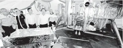  ??  ?? LIM menunjukka­n replika pengangkut­an di angkasa sambil diperhatik­an Pengarah Urusan China Science and Technology Museum (CSTM), Yin Hao (dua, kanan) pada majlis penyampaik­an replika pengangkut­an berkenaan bersama tiga replika roket bernilai RM 1 juta...