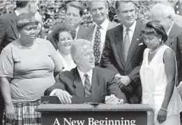  ?? J. SCOTT APPLEWHITE/AP ?? President Bill Clinton prepares to sign legislatio­n overhaulin­g America’s welfare system on Aug. 22, 1996, in the Rose Garden of the White House.