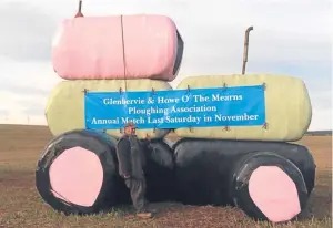  ??  ?? Associatio­n president Munro Smith beside some promotiona­l tractor bale art