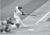  ?? ERIC RISBERG/ASSOCIATED PRESS ?? The Athletics’ Chad Pinder laces a two-run single in front of Chicago White Sox catcher Yasmani Grandal during the fifth inning of Game 3 Thursday in Oakland, California. The line drive to left stood up as the series-winning hit.