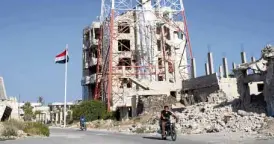  ?? —AFP ?? REBEL NOMORE A Syrian national flag flutters at a street in Daraa al-Balad, where the Syrian Civil War started in 2011.