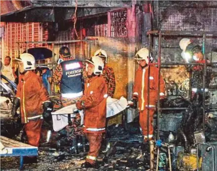  ?? BY ASWADI ALIAS PIC ?? Fire and Rescue personnel removing the body of the victim from the shophouse in Sentul on Tuesday.