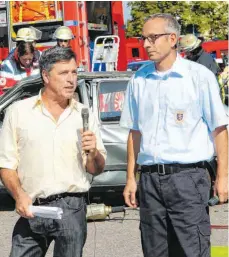  ?? FOTO: OSK ?? Klaus Ellinger (links) erläutert bei einer Großübung an der Oberschwab­enhalle im Jahre 2011 mit Kreisbrand­meister Oliver Surbeck (rechts) dem Publikum das Geschehen. Jetzt verabschie­det sich der Mediziner in den Ruhestand.