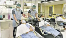  ?? SATISH BATE/HT ?? A hair stylist and a customer, clad in protective gear, at a salon in Juhu in Mumbai.