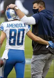  ?? BRETT CARLSEN — THE ASSOCIATED PRESS ?? Detroit Lions receiver Danny Amendola, left, and Tennessee Titans head coach Mike Vrabel talk before Sunday’s game. Detroit hired Matt Patricia instead of Vrabel in 2018.