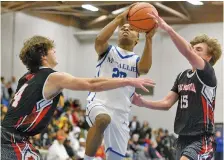  ?? STAFF PHOTO BY MATT HAMILTON ?? Signal Mountain’s Ben Timblin, left, and JB Zimmerman, right, defend as McCallie’s De’Shun Tipton drives to the hoop during the opening day of the Times Free Press Best of Preps basketball tournament Thursday at Chattanoog­a State.