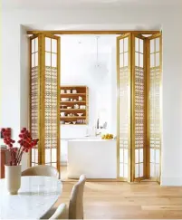  ??  ?? BELOW A four-metre-tall bronze and glass accordion door system by Demansou Constructi­on makes for an elegant room divider between the kitchen and dining areas.