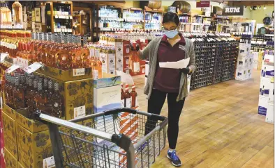  ?? Erik Trautmann / Hearst Connecticu­t Media ?? An employee at the Stew Leonard's Wine Shop prepares a pick-up order Thursday in Norwalk.