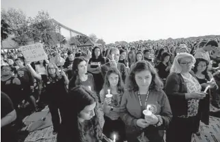  ?? RHONA WISE/AFP ?? Thousands of mourners hold candles during a candleligh­t vigil for victims of the Marjory Stoneman Douglas High School shooting in Parkland in February 2018.