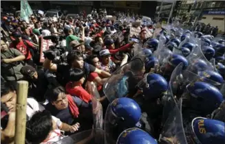  ?? AARON FAVILA, THE ASSOCIATED PRESS ?? Protesters scuffle with police as they are dispersed while trying to get near the U.S. Embassy in Manila, Philippine­s, on Sunday. The group was protesting the visit of U.S. President Donald Trump.