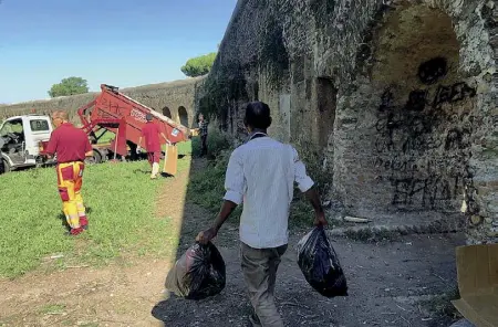  ??  ?? Decoro Un momento dello sgombero dell’accampamen­to abusivo sotto gli archi antichi nel parco degli Acquedotti