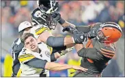  ??  ?? Browns defensive end Myles Garrett (95) hits Steelers quarterbac­k Mason Rudolph (2) with the former Oklahoma State star's helmet late in Cleveland's 21-7 win Thursday. [AP PHOTO/DAVID RICHARD]