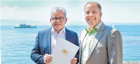  ?? FOTO: AH ?? Nicht viel mit Dienst zu tun: Guido Wolf (links) bringt mit einem Förderbesc­heid Langenarge­ns Bürgermeis­ter Achim Krafft zum Strahlen.