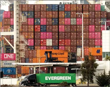  ?? (AP/Noah Berger) ?? A truck passes a heavily laden container ship at the Port of Oakland, Calif., in October. Major ports around the United States will soon be getting help to clear persistent backlogs that have slowed deliveries of goods.