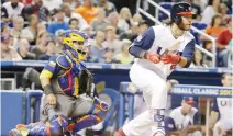  ??  ?? Brandon Crawford, right, follows through on a single as Colombia catcher Jhonatan Solano watches during the sixth inning in a first-round game of the World Baseball Classic, in Miami, on Friday night. (AP)