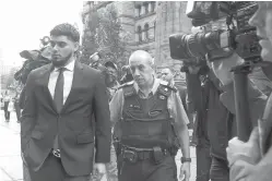  ?? Chris Young/The Canadian Press via AP ?? ■ Houston Astros’ Roberto Osuna, left, leaves a Toronto court Tuesday. The former Toronto Blue Jays pitcher agreed to a peace bond that led to the withdrawal of an assault charge against him. He was charged in May with assault in a domestic violence case.