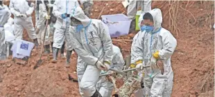  ?? ZHOU HUA/AP ?? Rescuers carry a piece of plane wreckage from the China Eastern flight crash site in Tengxian County, southern China’s Guangxi Zhuang Autonomous Region, on March 25.