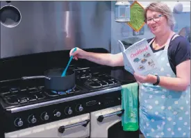  ??  ?? Mairi Fleck tries out a recipe from the new Caring and Sharing cook book.