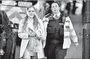  ?? AP/DOMINIC LIPINSKI ?? A police officer helps an injured commuter after Friday’s bomb attack in a subway car in London.