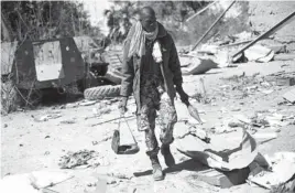  ?? AP PHOTO ?? A Malian soldier walks inside a military camp used by radical Islamists and bombarded by French warplanes, in Diabaly, Mali, about 320 miles north of the capital Bamako. French and Malian troops Monday took control of the town and patrolled the streets...