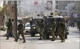  ?? MAJDI MOHAMMED — THE ASSOCIATED PRESS ?? Israeli soldiers take up positions at the scene of a Palestinia­n shooting attack at the Hawara checkpoint, near the West Bank city of Nablus, on Sunday.