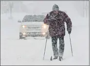  ?? AP/Erie Times-News/JACK HANRAHAN ?? Timothy Gigone of Erie, Pa., uses skis to move along an Erie street Saturday as forecaster­s predicted several inches of snow for the area.