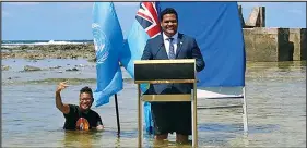  ?? Photo: RNZ ?? Tuvalu’s foreign minister, Simon Kofe, gives a COP26 statement while standing in the ocean in Funafuti.