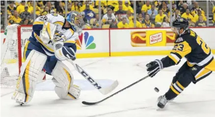  ?? THE ASSOCIATED PRESS ?? Nashville Predators goalie Pekka Rinne, left, clears the puck past the Pittsburgh Penguins’ Scott Wilson on Monday during the second period in the first game of the Stanley Cup Final. The Penguins won 5-3.
