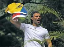  ?? FERNANDO LLANO/THE ASSOCIATED PRESS ?? Opposition leader Leopoldo Lopez holds a Venezuelan national flag Saturday as he greets supporters outside his home in Caracas, Venezuela. Lopez was released from prison and placed under house arrest Saturday after more than three years in a military...