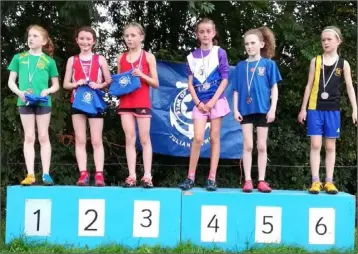  ??  ?? Abaigh Moonan and Enya Silkena of St Gerards AC on the podium after their second and third place finishes at Star of the Sea Cross-Country Races.