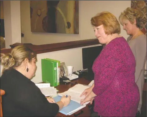  ?? Submitted photo ?? NEW CHALLENGES: From left, Amber Miles, Donna Neville and Kristi Huddleston work through the challenges of new government regulation­s pertaining to mortgage lending.