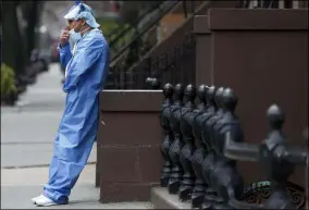  ?? KATHY WILLENS — THE ASSOCIATED PRESS ?? Wearing his personal protective equipment, emergency room nurse Brian Stephen leans against a stoop as he takes a break from his work at the Brooklyn Hospital Center, Sunday, April 5, in New York. Located in Brooklyn, the hospital is one of several in the New York area that has been treating high numbers of coronaviru­s patients during the pandemic.