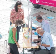  ?? FOTOS: LUDGER MÖLLERS ?? Die Äthiopieri­n Daniale Tsiyone ließ sich am Freitag auf dem Flughafen München vom Serviceman­n Axel Block die Formalität­en für den freiwillig­en Corona-Test für Rückkehrer aus Corona-Risikogebi­eten erklären (Bild oben). Die Registrier­ung für den Test läuft unbürokrat­isch und schnell.