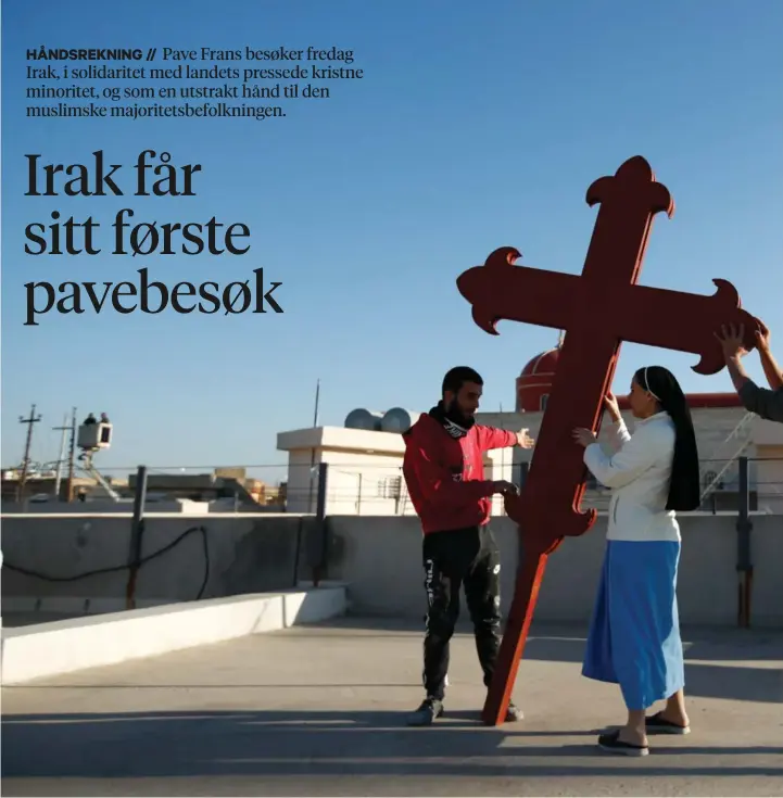  ??  ?? Kristne irakere monterer et kors på en kirke i Qaraqosh. Byen, som også er kjent som Hamdaniyah og Bakhdida, var tidligere landets største kristne by.