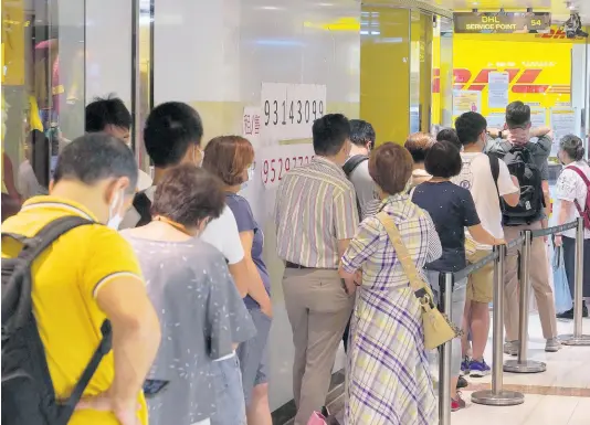  ?? AP ?? People queue up outside the DHL Express store in Hong Kong yesterday.