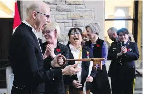  ??  ?? Left: House of Commons Speaker Geoff Regan jokes about the size of the symbolic key to the new digs during a ceremony last week. Right: Regan checks out the view from his new chair. The Speaker is responsibl­e for keeping order and calling MPs to speak.