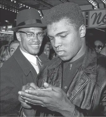  ?? AP PHOTO ?? In this March 1, 1964, file photo, world heavyweigh­t boxing champion, Muhammad Ali, right, is shown with Black Muslim Leader, Malcolm X, outside the Trans-Lux Newsreel Theater on Broadway at 49th Street in New York City. They had just watched a...