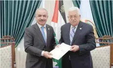 ?? — Reuters ?? Mohammad Shtayyeh receives a designatio­n letter from Mahmud Abbas to form a new Palestinia­n government in Ramallah.