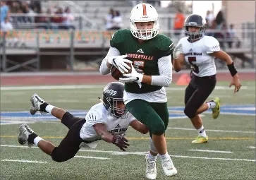  ?? RECORDER PHOTO BY CHIEKO HARA ?? Portervill­e High School’s Aaron Cruz runs with the ball after receiving a pass as Granite Hills High School’s Ramon Valles attempts to tackle him from behind Friday, Aug. 24, during the first half at Jacob Rankin Stadium in Portervill­e.